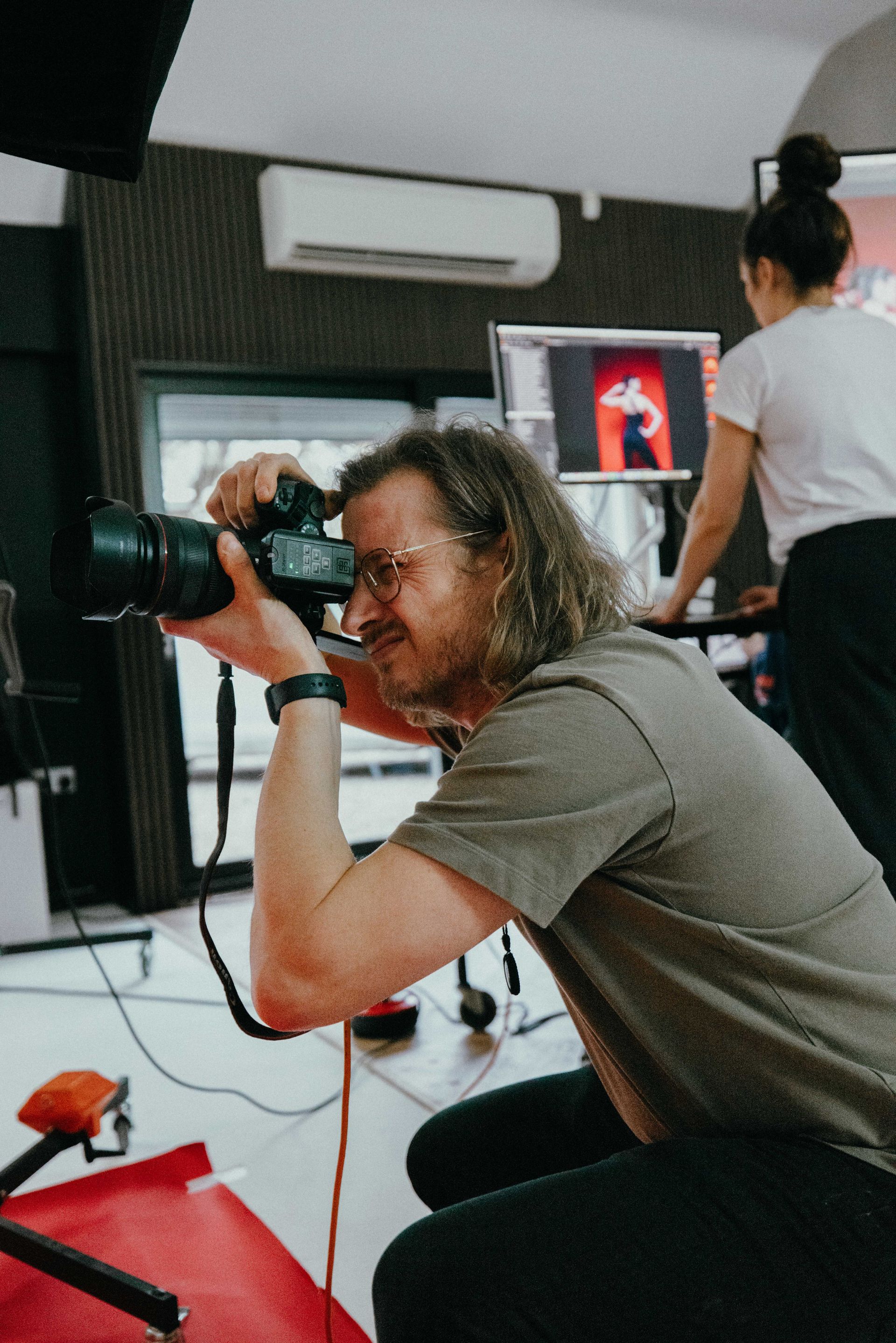 A man is taking a picture with a camera in a studio.