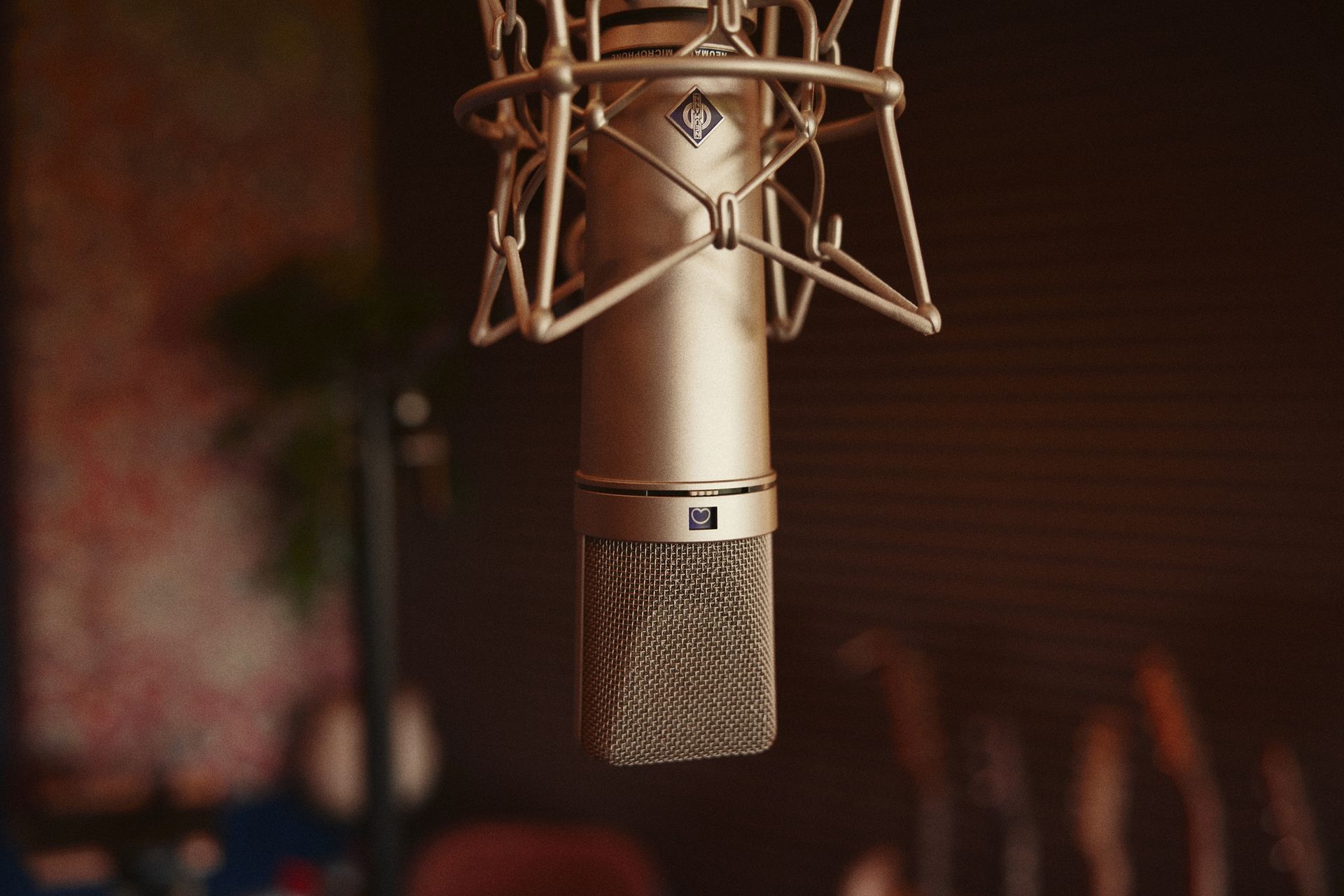 A close up of a microphone hanging from a stand in a dark room.