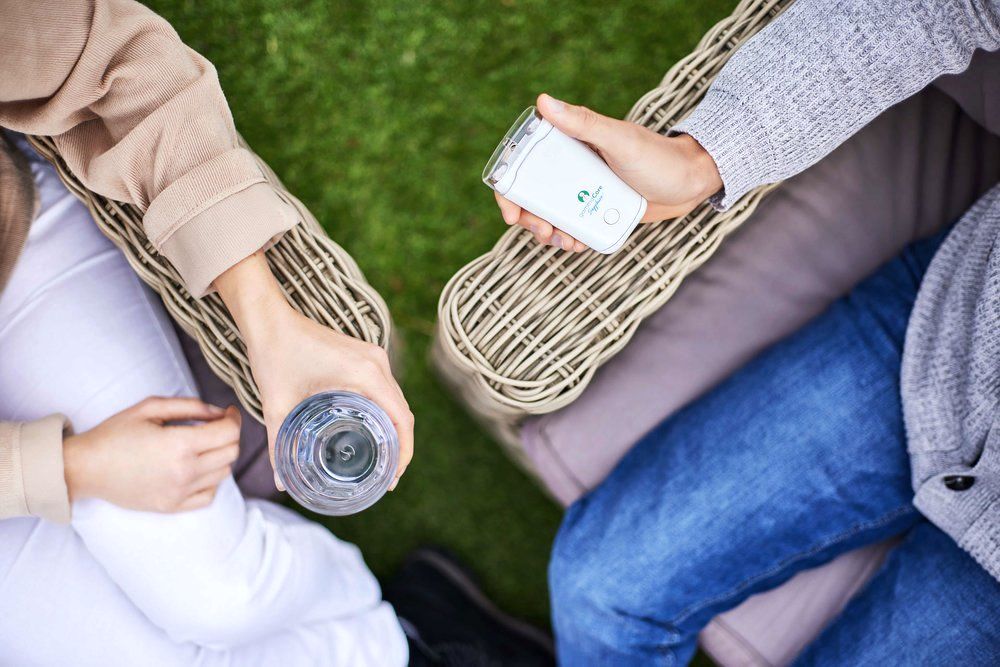 A woman is holding a remote control and a bottle of water.