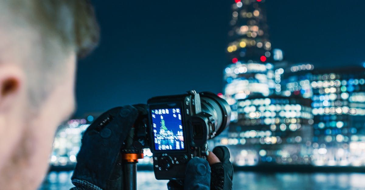 A man is taking a picture of a christmas tree with a camera.