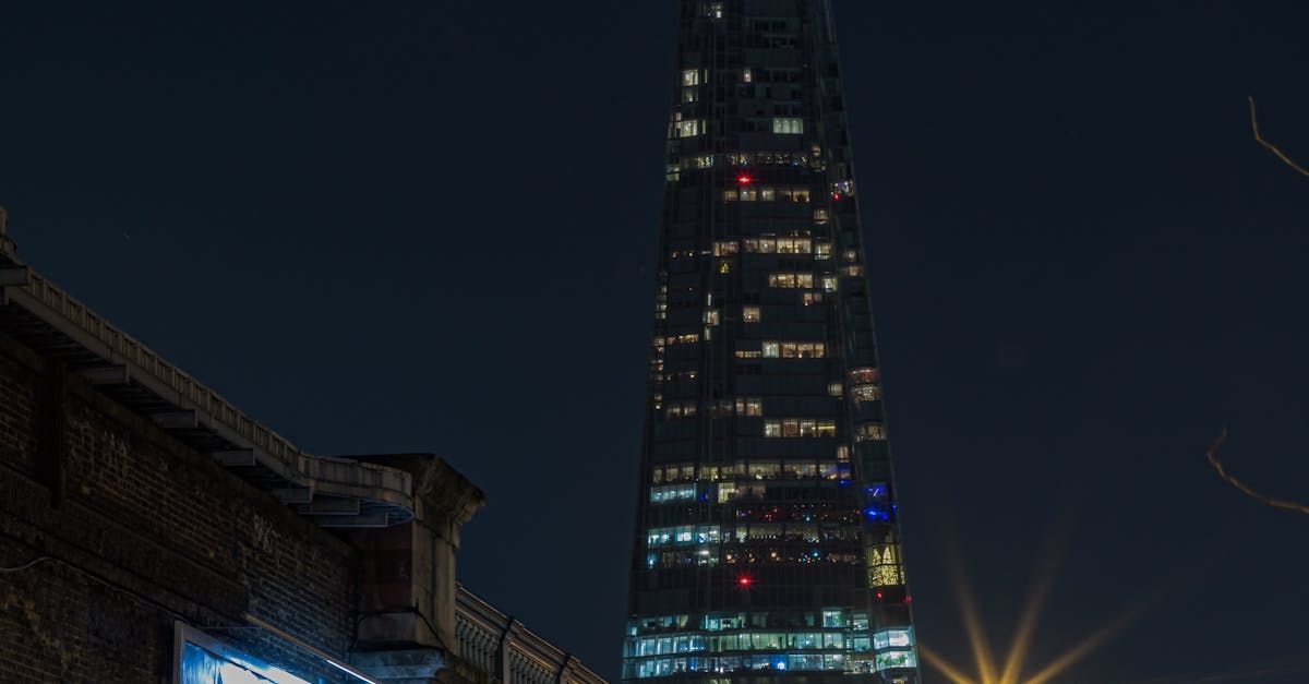 A tall building is lit up at night in a city.