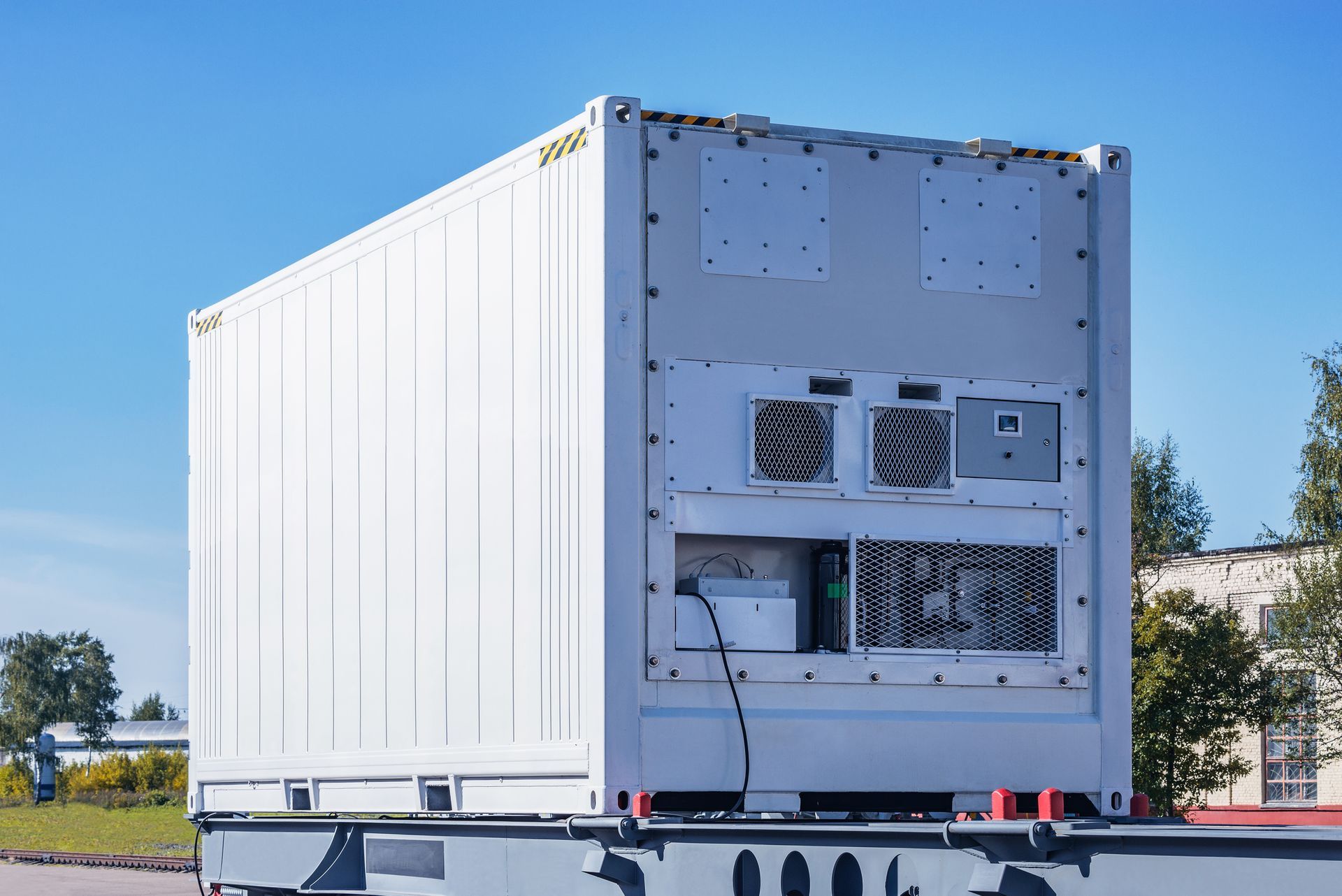 A white shipping container is sitting on top of a trailer.