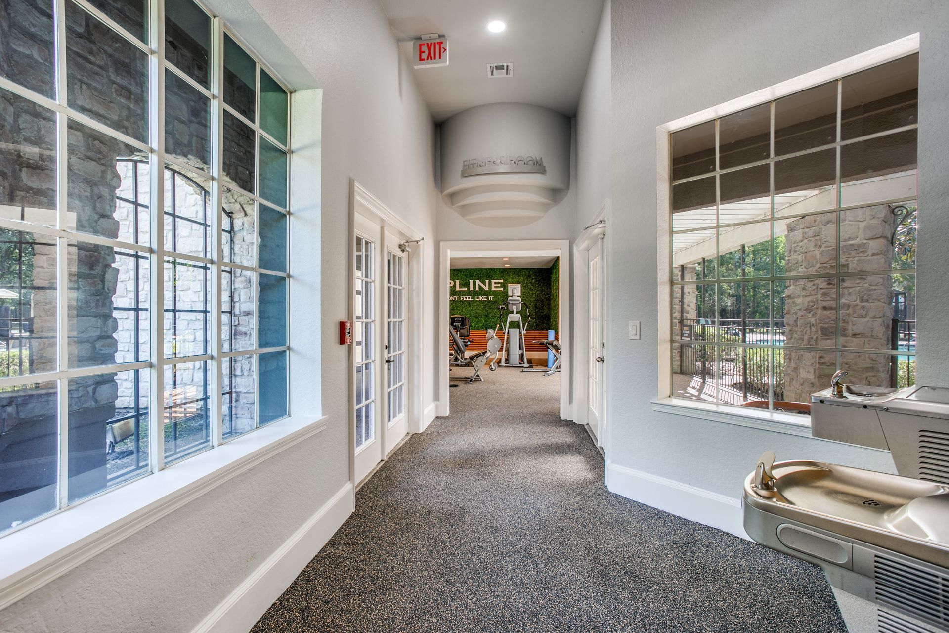A hallway with a water fountain in the middle of it at Marquis Champions Forest offers apartments for rent in Klein ISD.