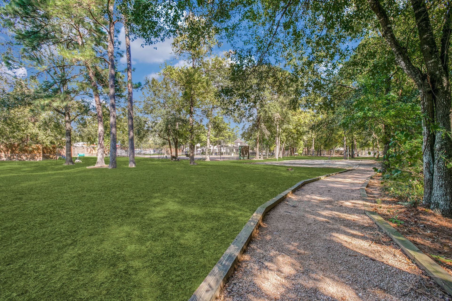A dirt path going through a park surrounded by trees and grass at Marquis Champions Forest offers luxury apartments for rent in Houston, TX.