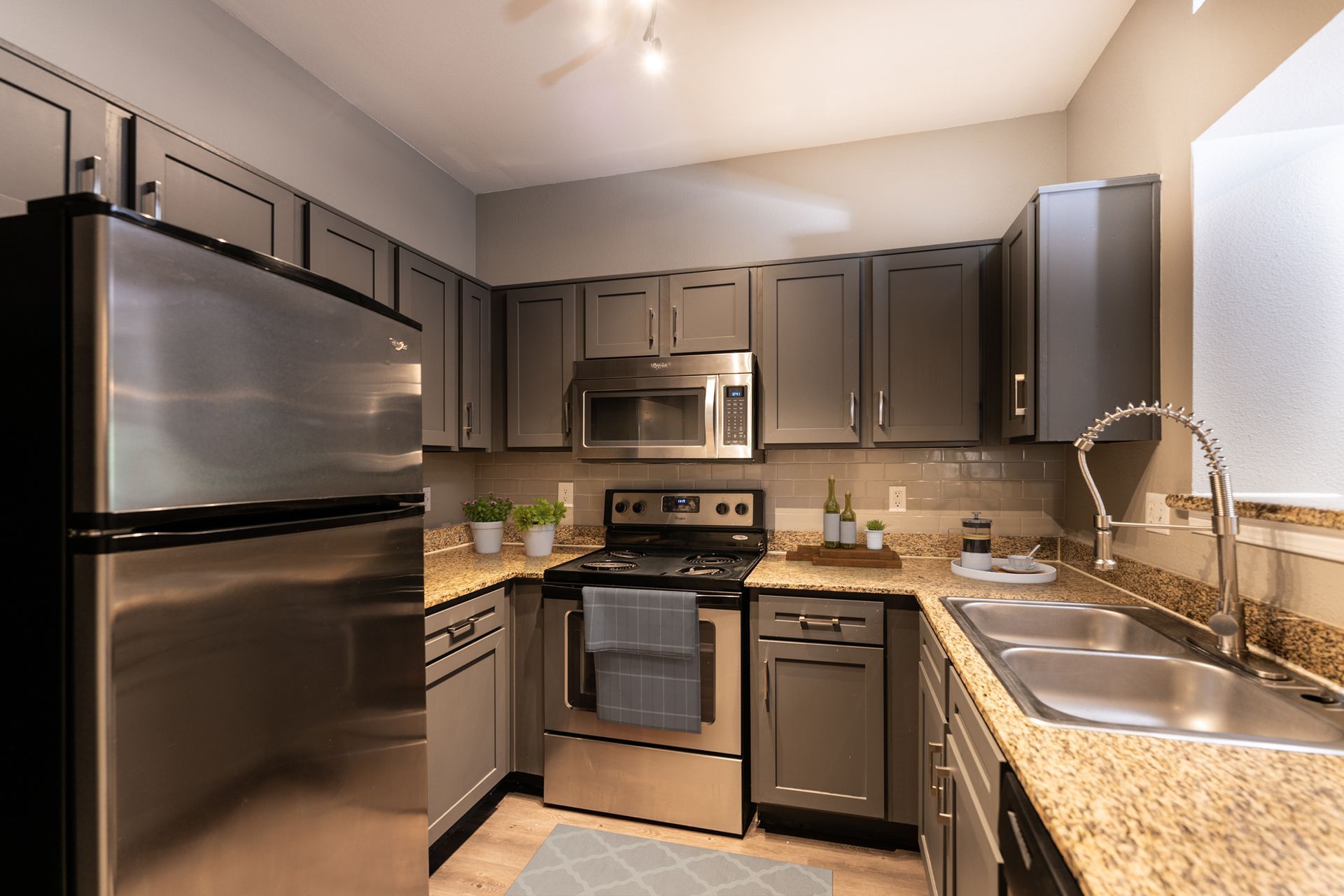 A kitchen with stainless steel appliances and granite counter tops at Marquis Champions Forest offers apartments in Houston, TX.