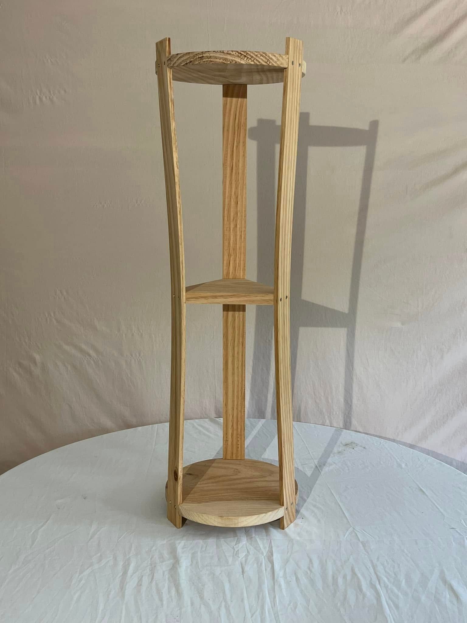 A wooden shelf is sitting on top of a white table cloth.