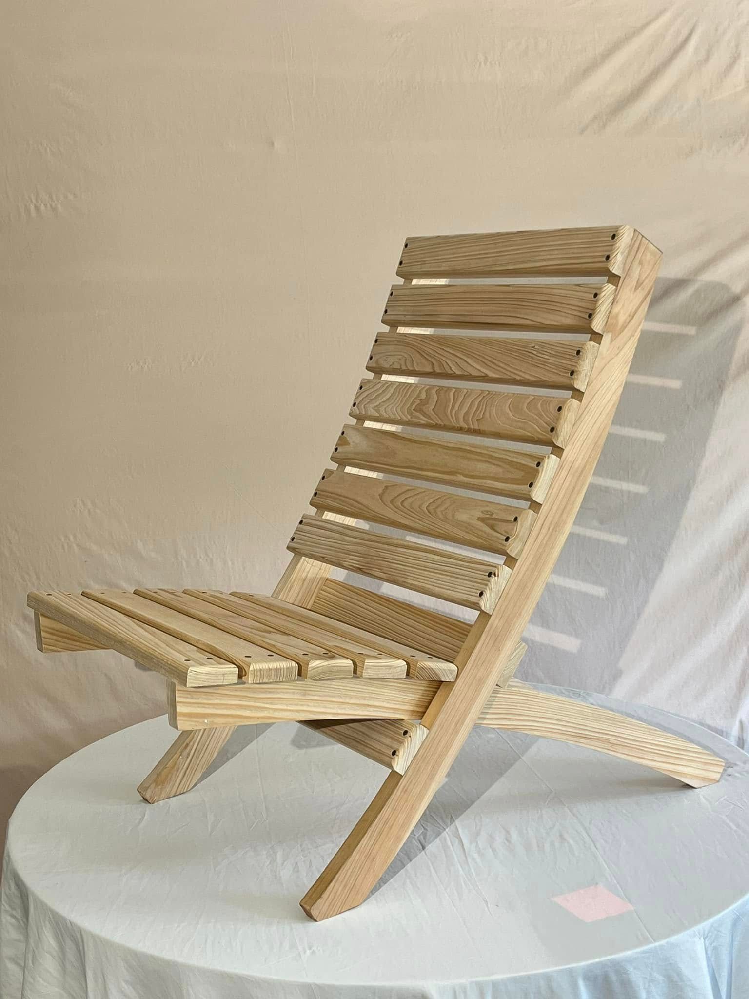 A wooden folding chair is sitting on top of a white table.