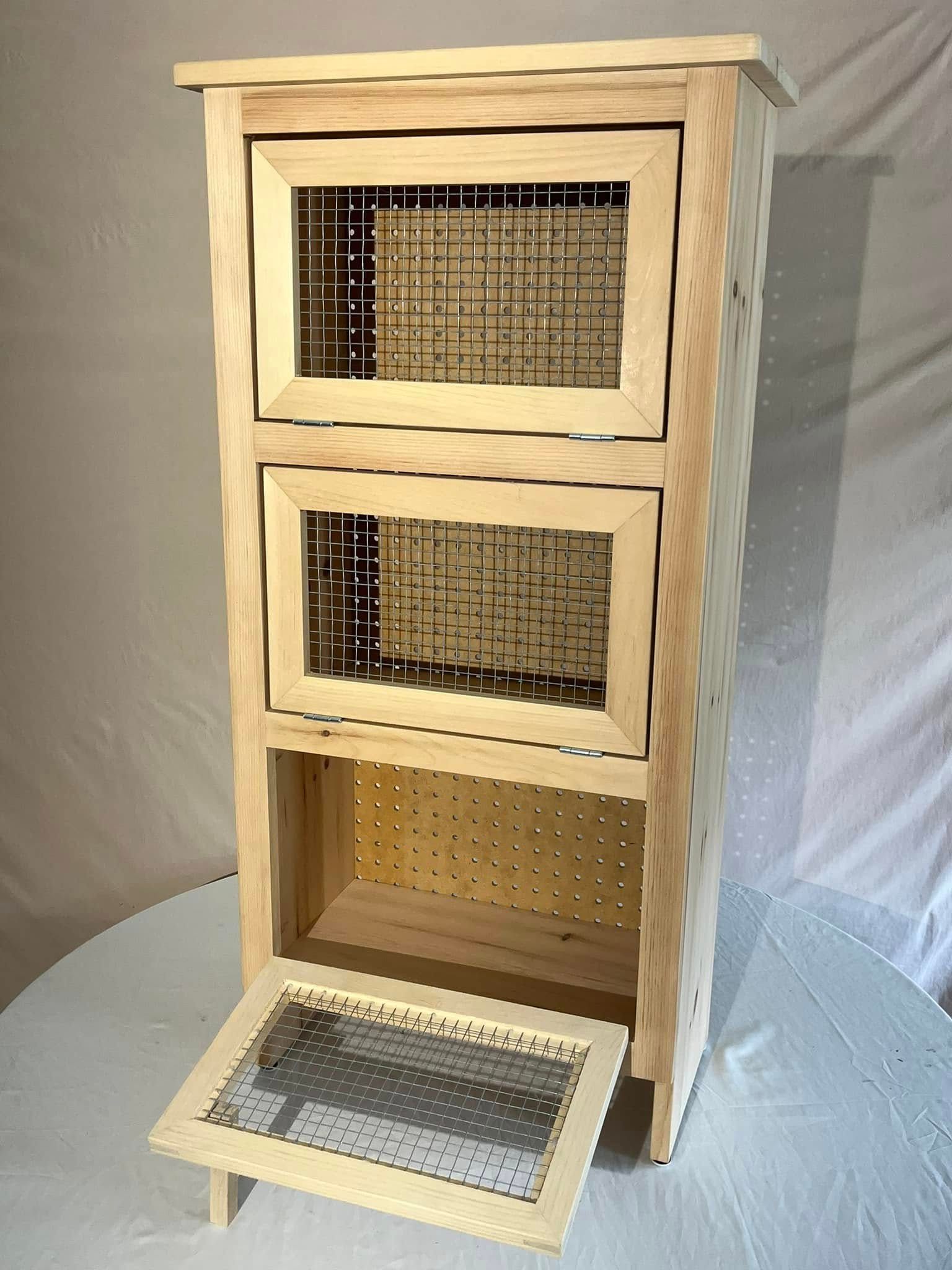 A wooden cabinet with three drawers and a glass door