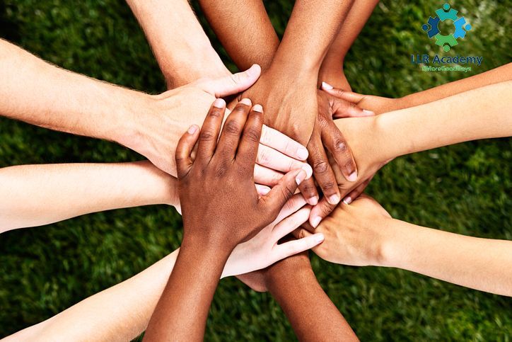Hands of diverse skin tones joined together.