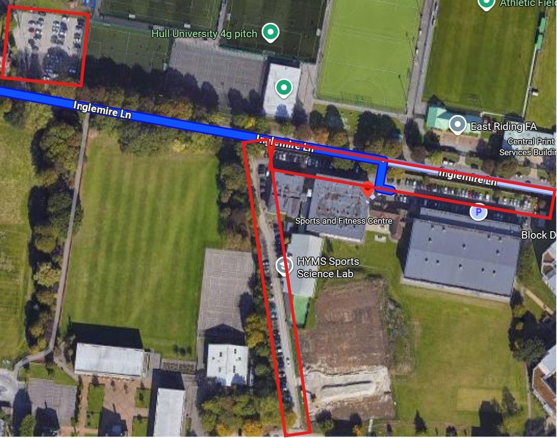 Aerial view of sports fields and buildings with blue path and red borders highlighting areas.