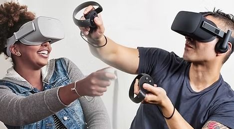 A man and a woman are wearing virtual reality headsets and holding controllers.