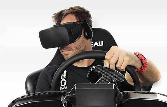 A man wearing a virtual reality headset is driving a car.