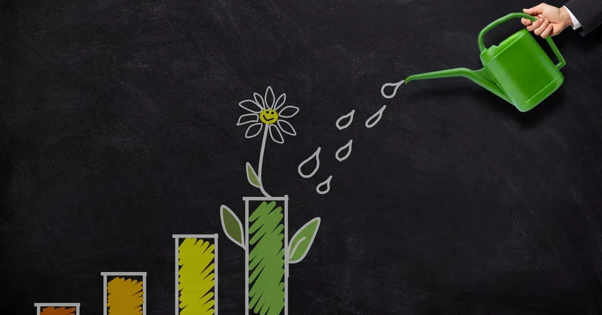 Watering can pouring water onto a chalk-drawn plant growing from rising bar graph bars