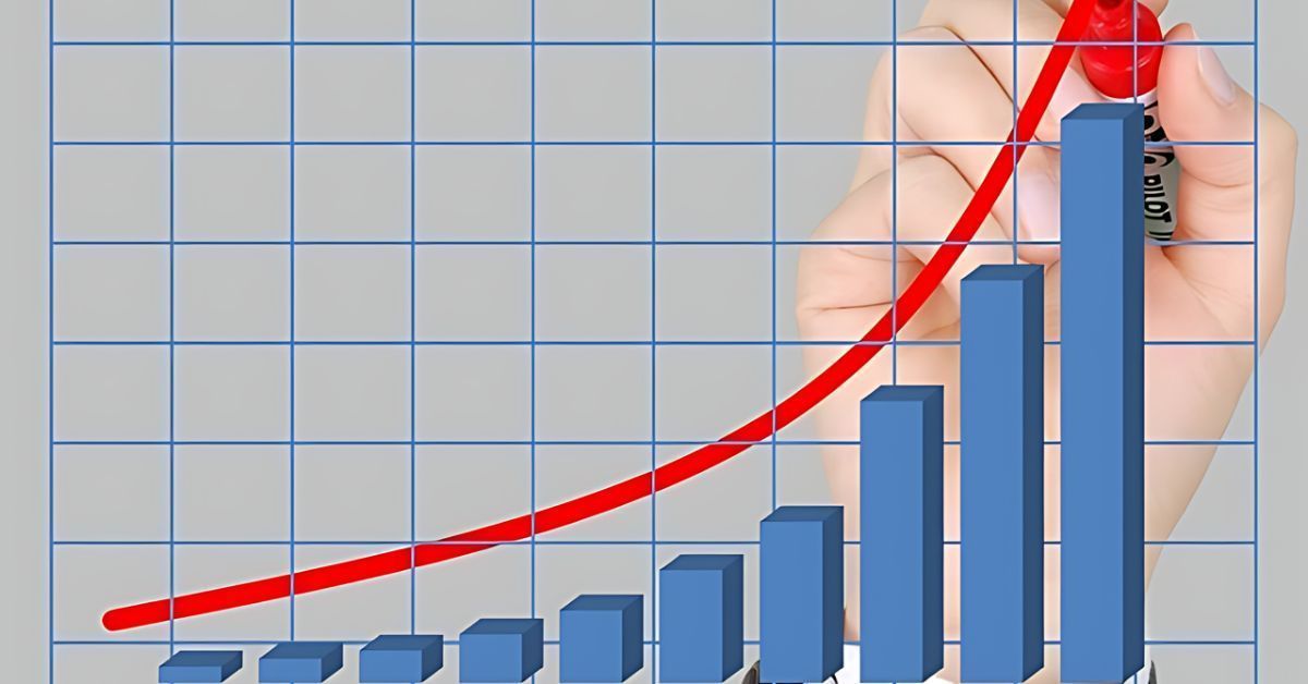 Blue bar chart rising with a red upward trend line in front of a hand on a grid background