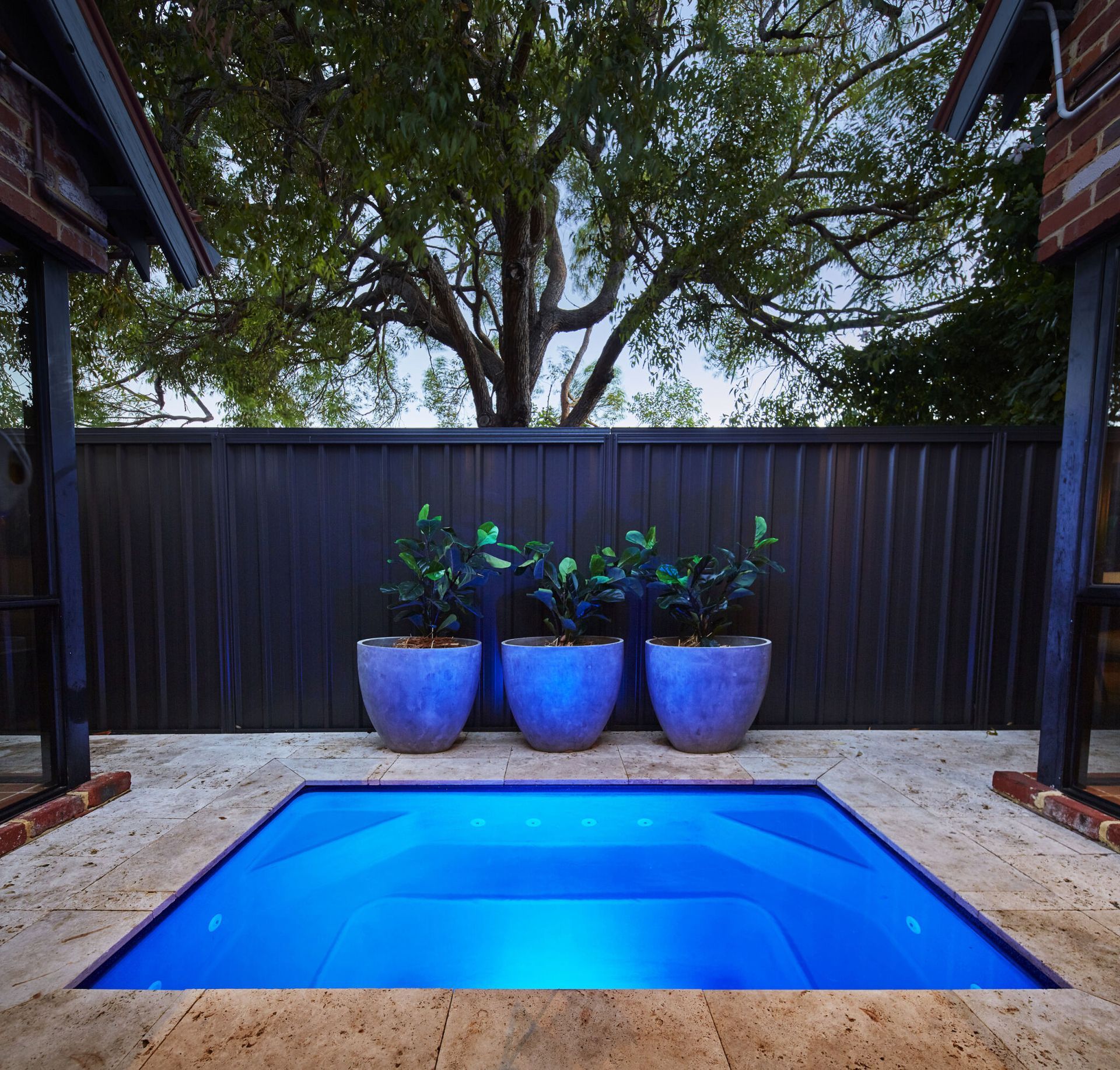 A Large Swimming Pool With A Glass Fence Around It — Gibson Family Pools Pty Ltd In Port Macquarie, NSW