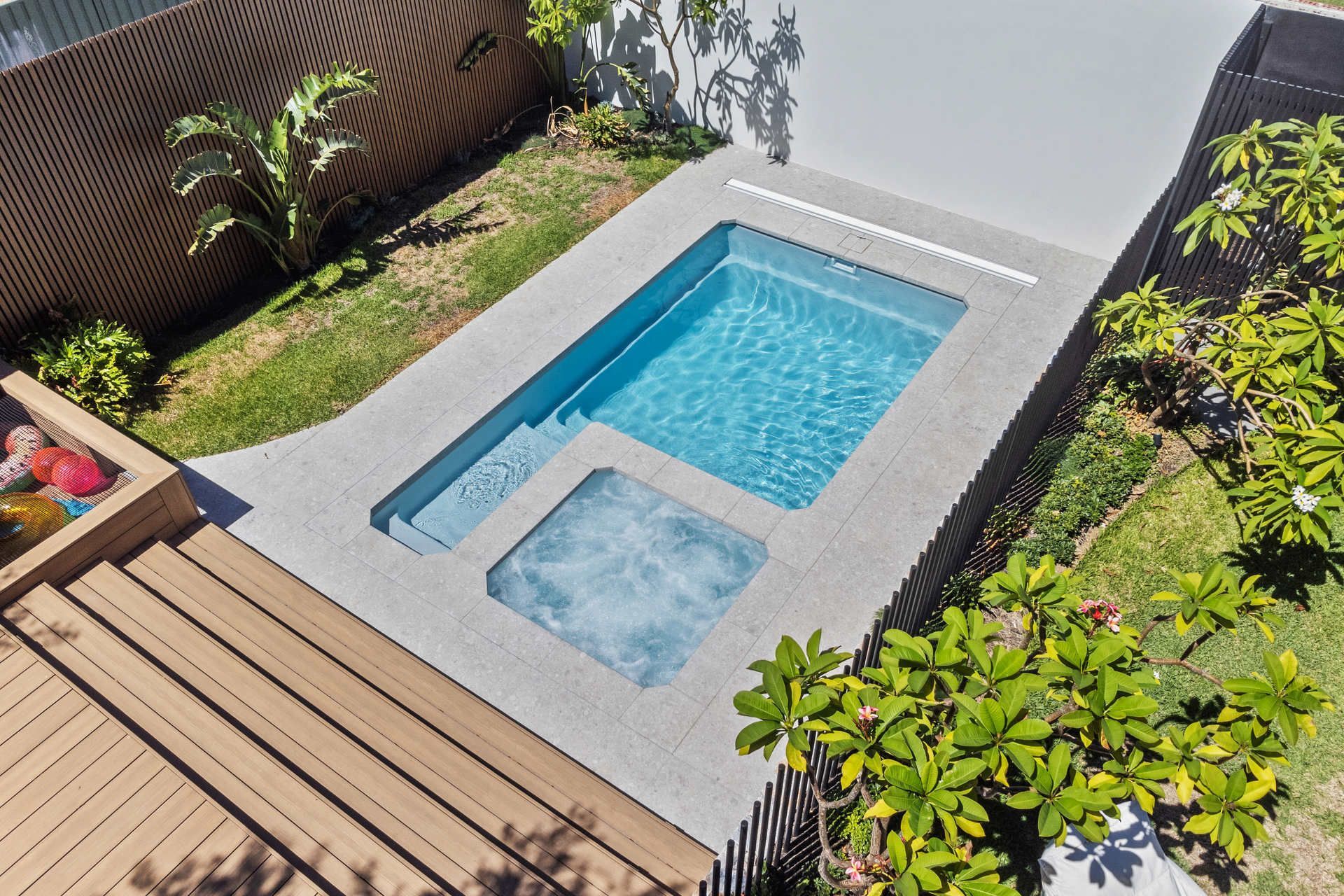 A Large Swimming Pool With A Glass Fence Around It — Gibson Family Pools Pty Ltd In Port Macquarie, NSW