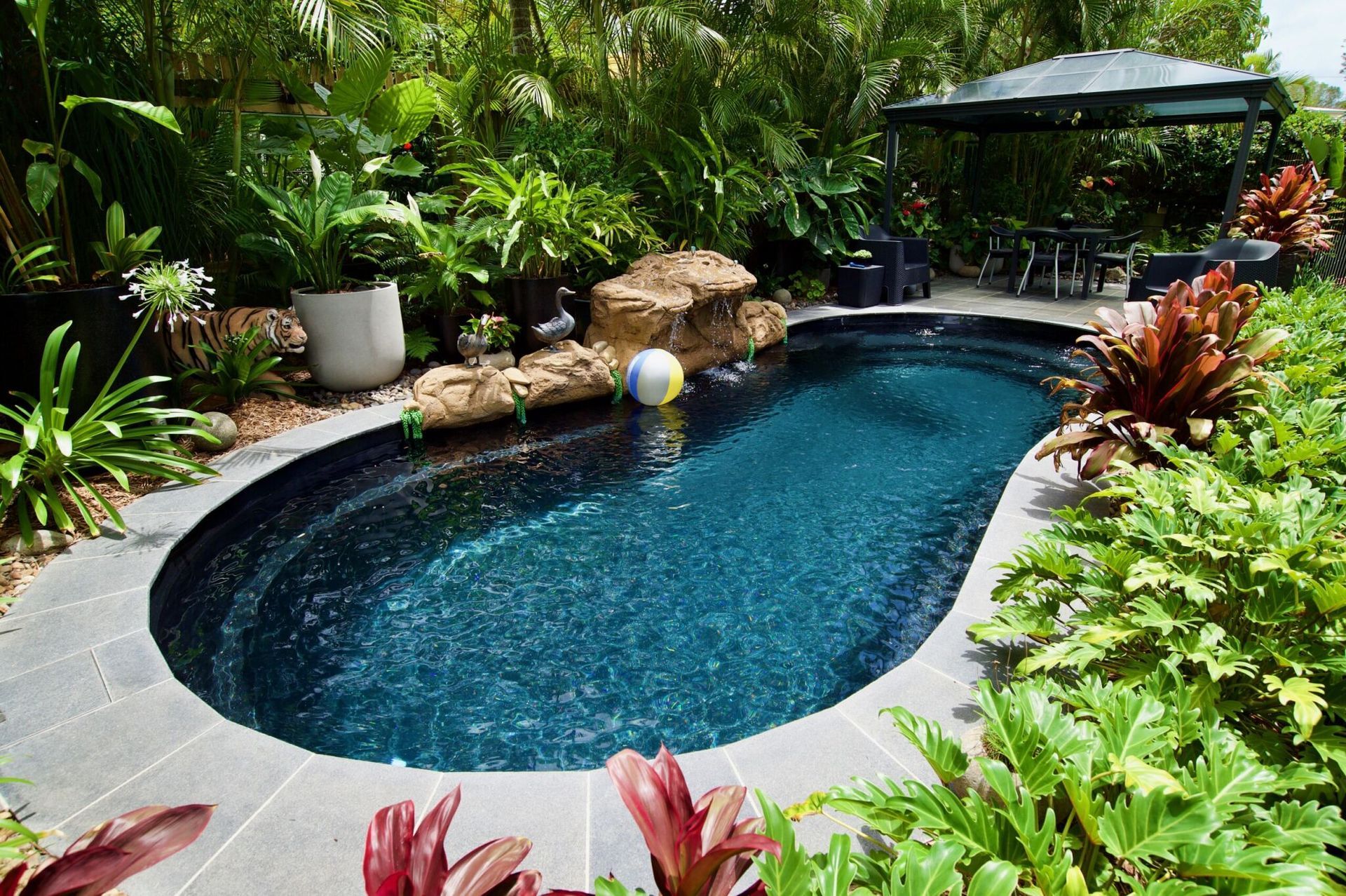 A Large Swimming Pool With A Glass Fence Around It — Gibson Family Pools Pty Ltd In Port Macquarie, NSW