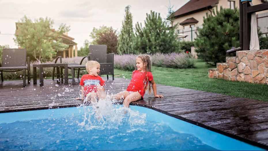 A Boy and a Girl Are Sitting on the Edge of a Swimming Pool — Gibson Family Pools Pty Ltd In Port Macquarie, NSW