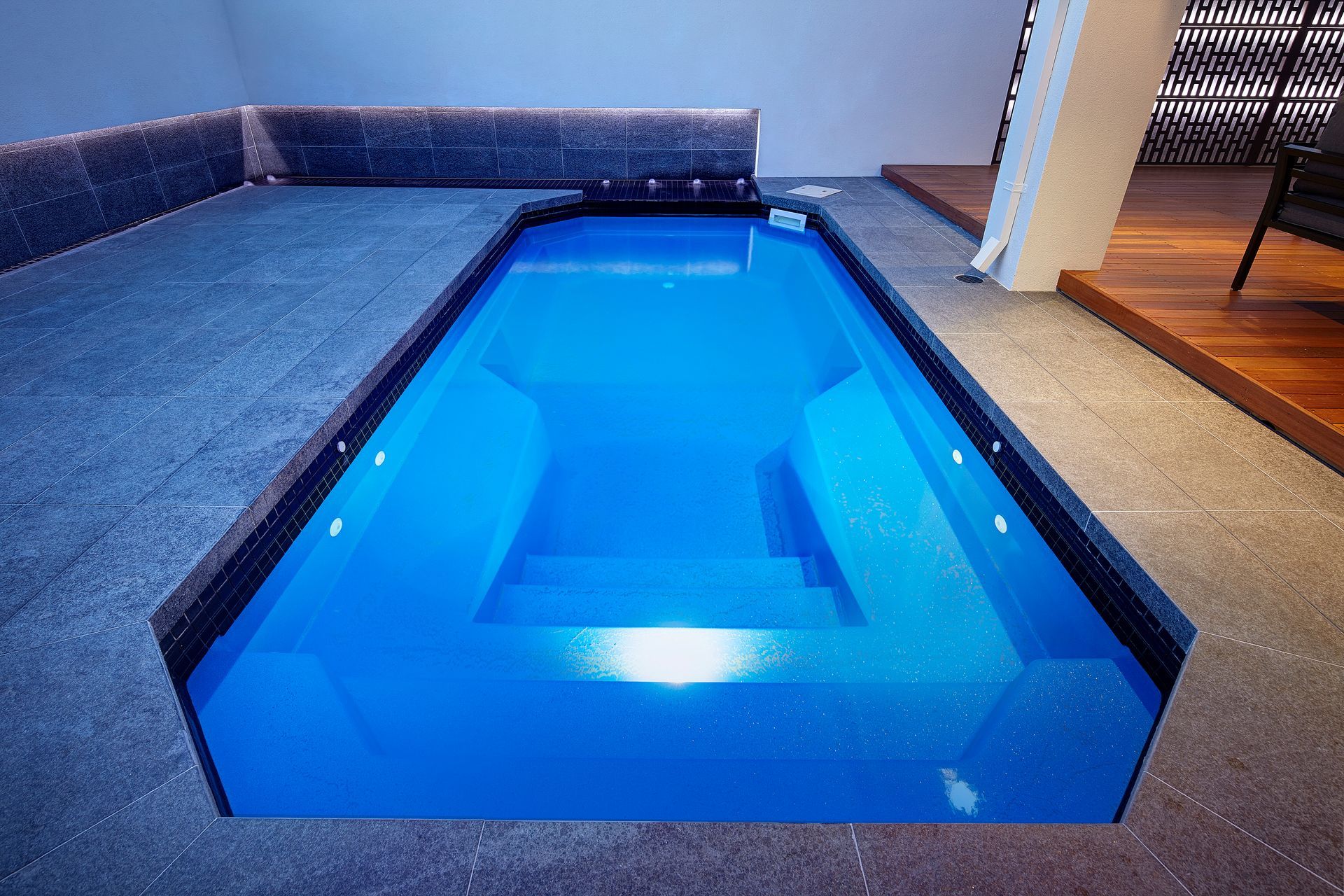 A Woman Is Swimming In A Hot Tub At A Spa — Gibson Family Pools Pty Ltd In Port Macquarie, NSW