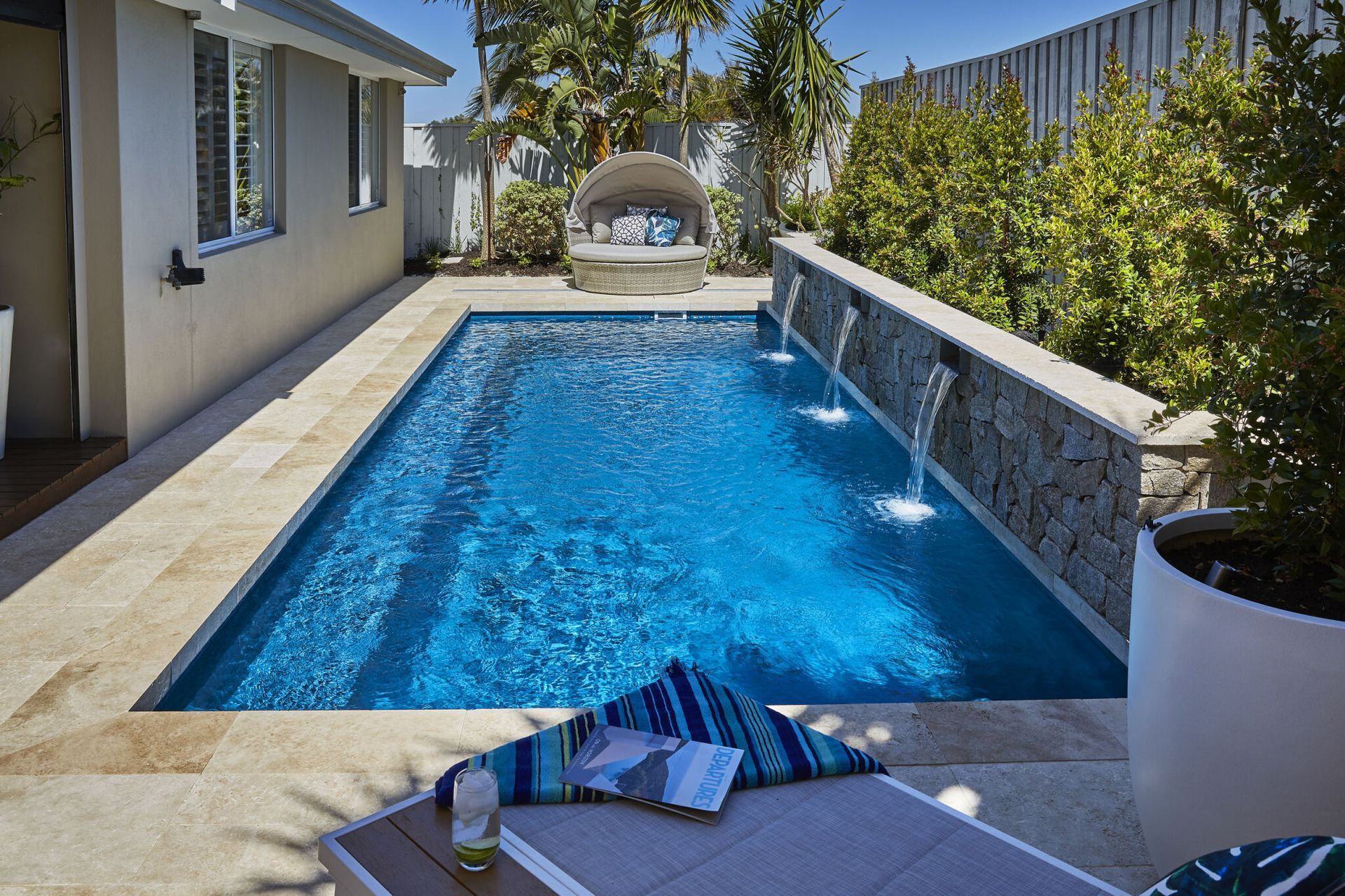 A Large Swimming Pool With A Glass Fence Around It — Gibson Family Pools Pty Ltd In Port Macquarie, NSW