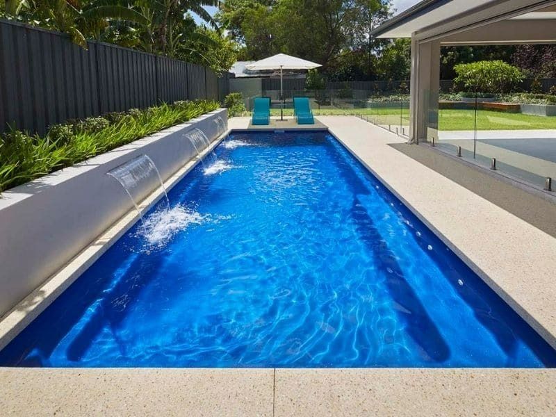 A Large Swimming Pool With A Waterfall In The Middle — Gibson Family Pools Pty Ltd In Port Macquarie, NSW