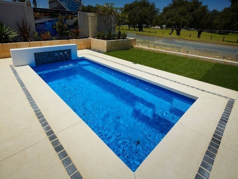 A Large Swimming Pool With A Waterfall In The Middle — Gibson Family Pools Pty Ltd In Port Macquarie, NSW