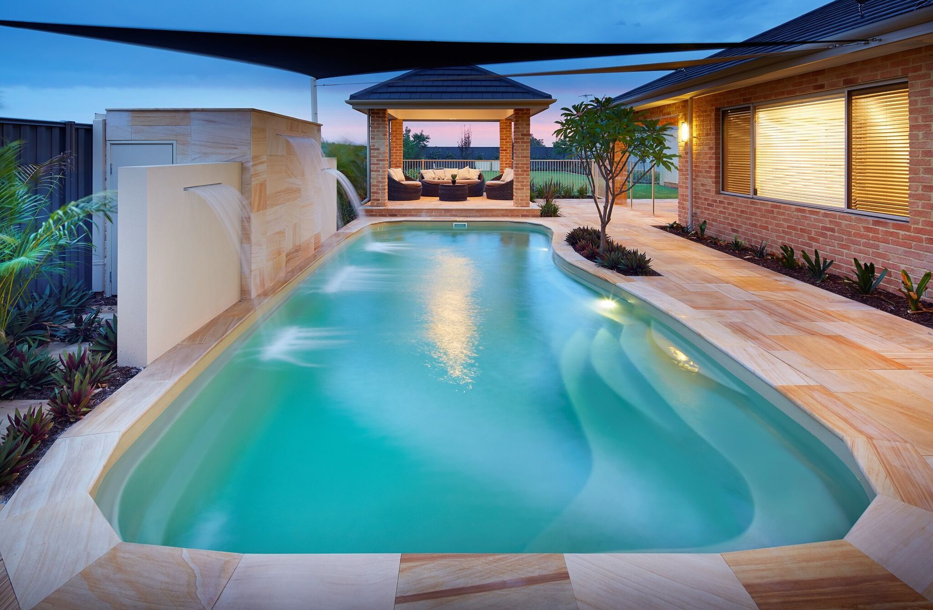 A Large Swimming Pool With A Glass Fence Around It — Gibson Family Pools Pty Ltd In Port Macquarie, NSW