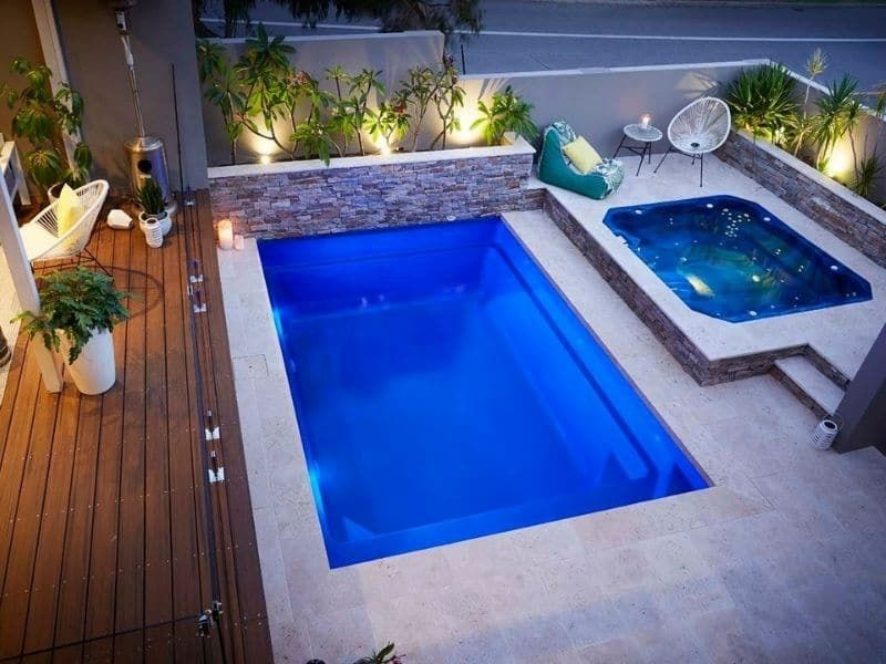 A Large Blue Swimming Pool With A Hot Tub Next To It — Gibson Family Pools Pty Ltd In Port Macquarie, NSW