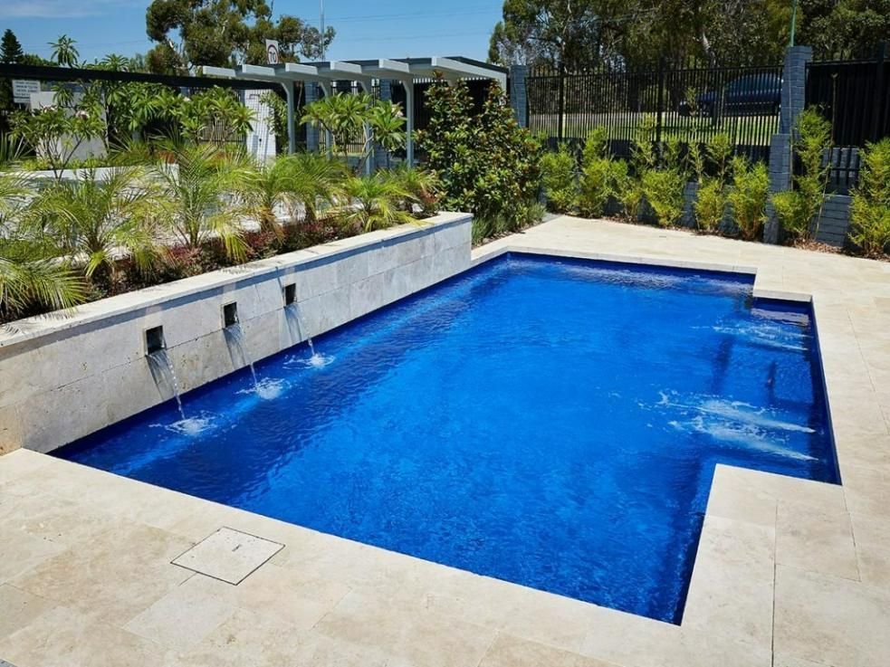 A Large Swimming Pool With A Waterfall In The Middle — Gibson Family Pools Pty Ltd In Port Macquarie, NSW