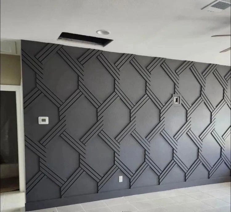 Empty modern room with a dark gray geometric accent wall and recessed ceiling opening