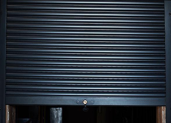 a black roller shutter is open in a dark room .