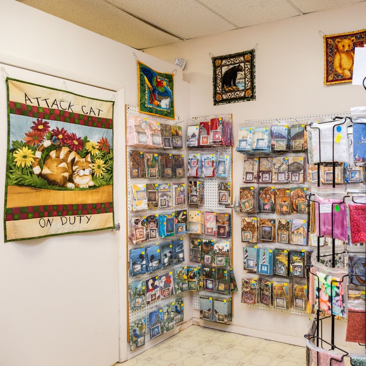 Craft and gift shop corner with hanging cards, framed art, and colorful merchandise displays