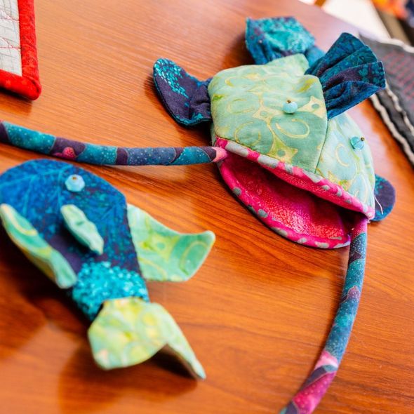 Colorful handmade fabric turtle and fish on a wooden surface
