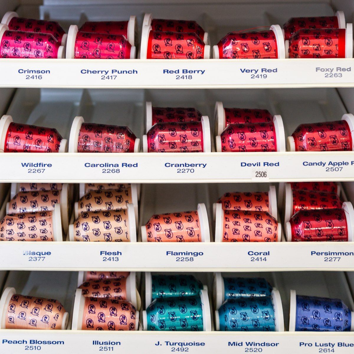 Shelves of colorful bottled drinks arranged in rows on a store display.