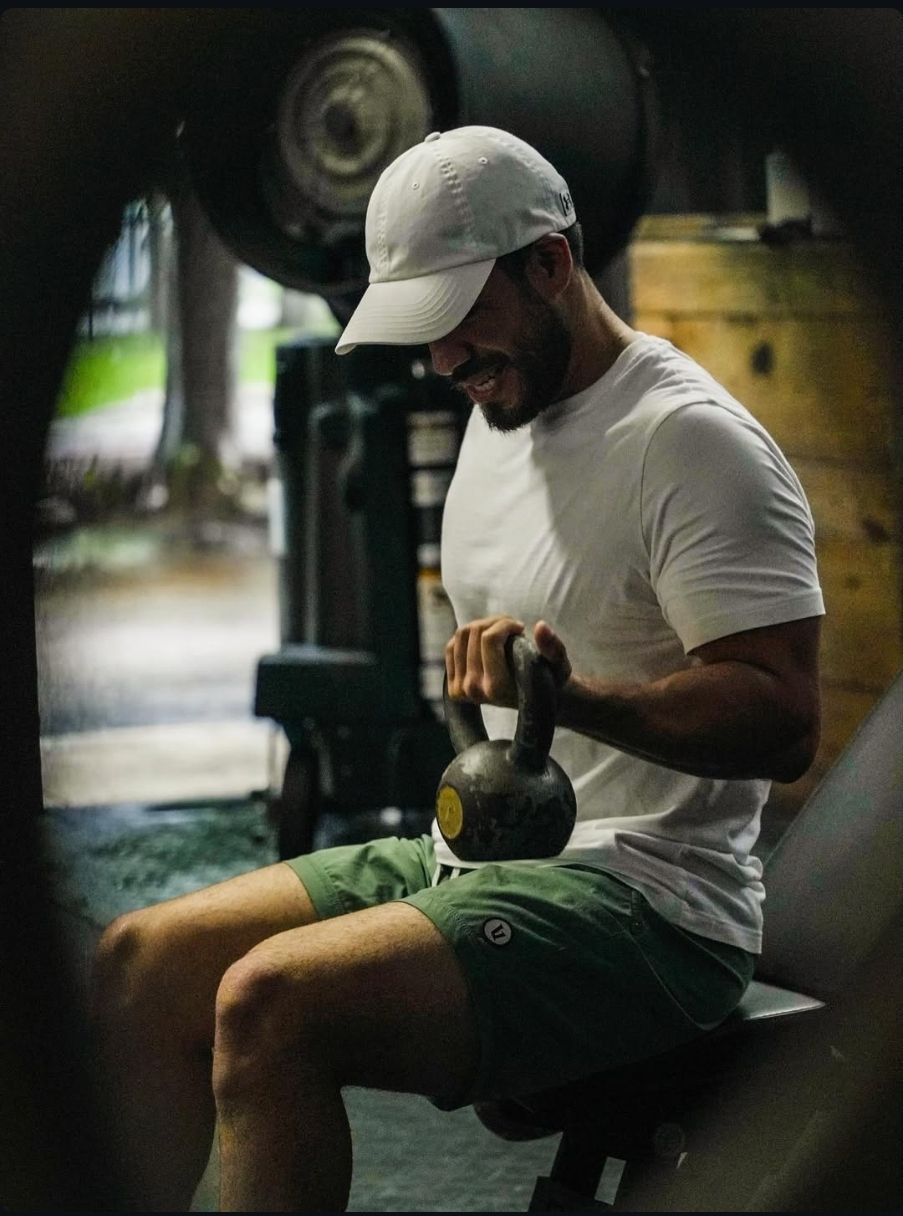 A man is lifting a barbell in a gym.