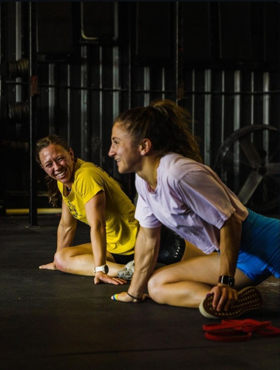 A woman is pulling a sled with weights in a gym.