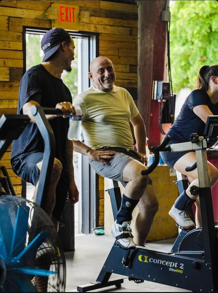 A black and white photo of a woman squatting with dumbbells in a gym