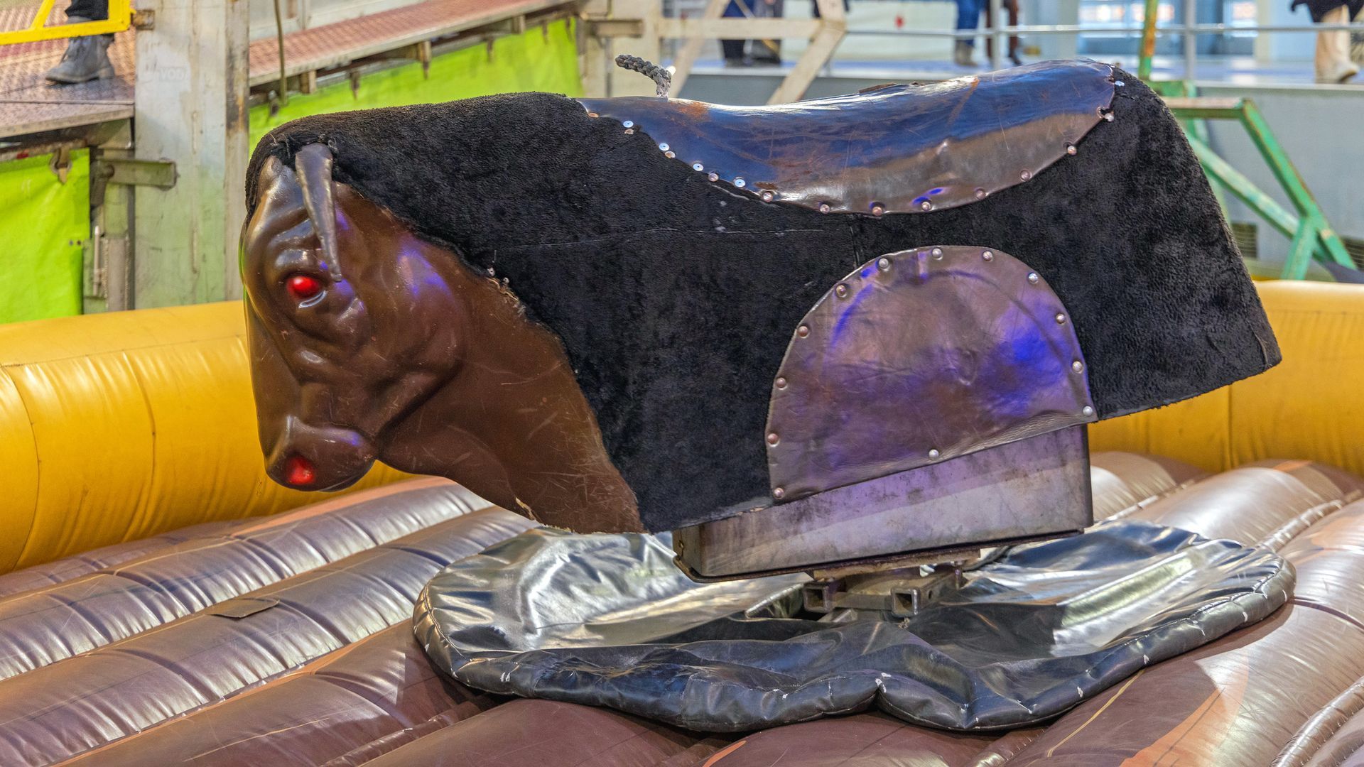 A mechanical bull with red eyes is sitting on top of a table.