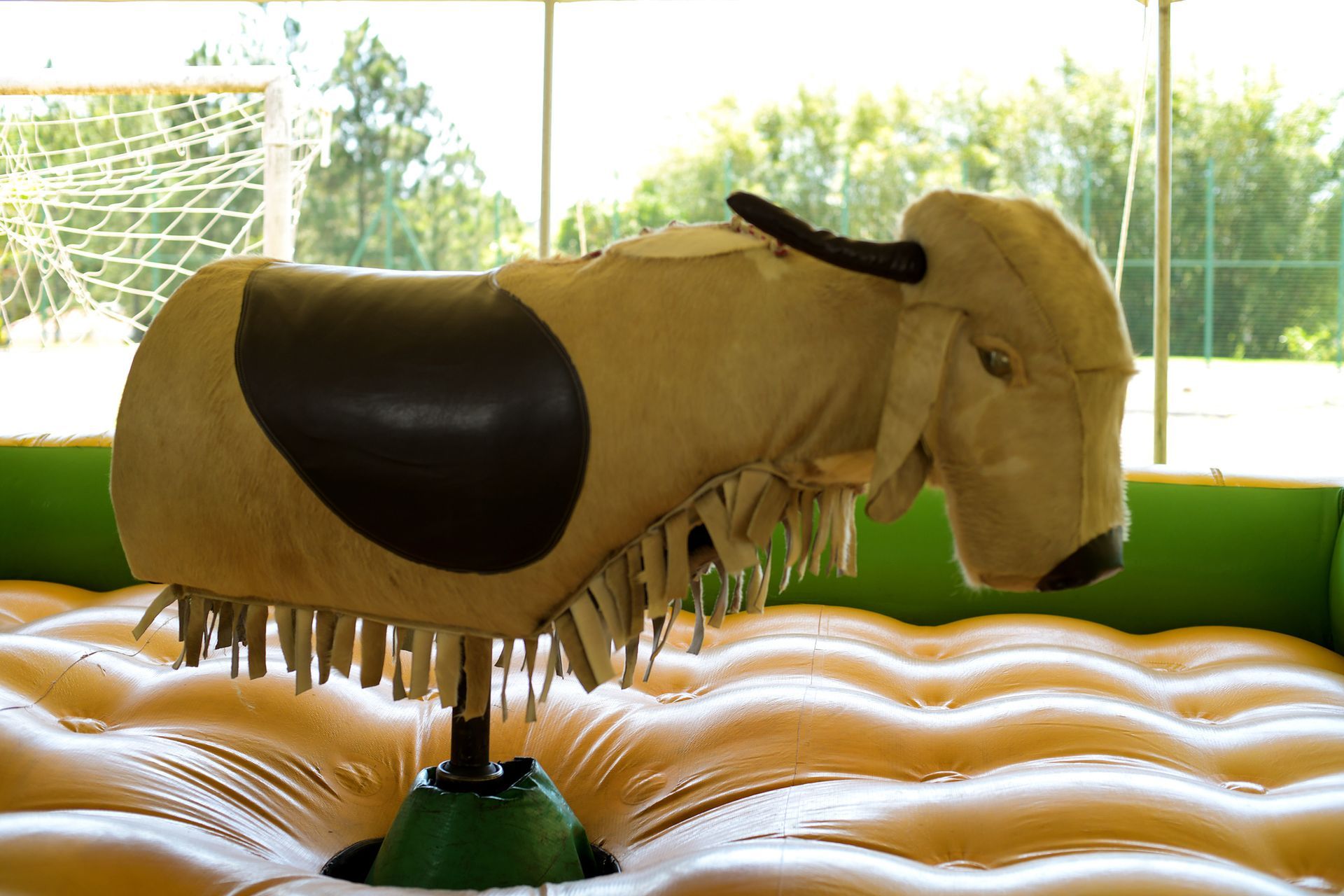 A mechanical bull is sitting on top of an inflatable mat