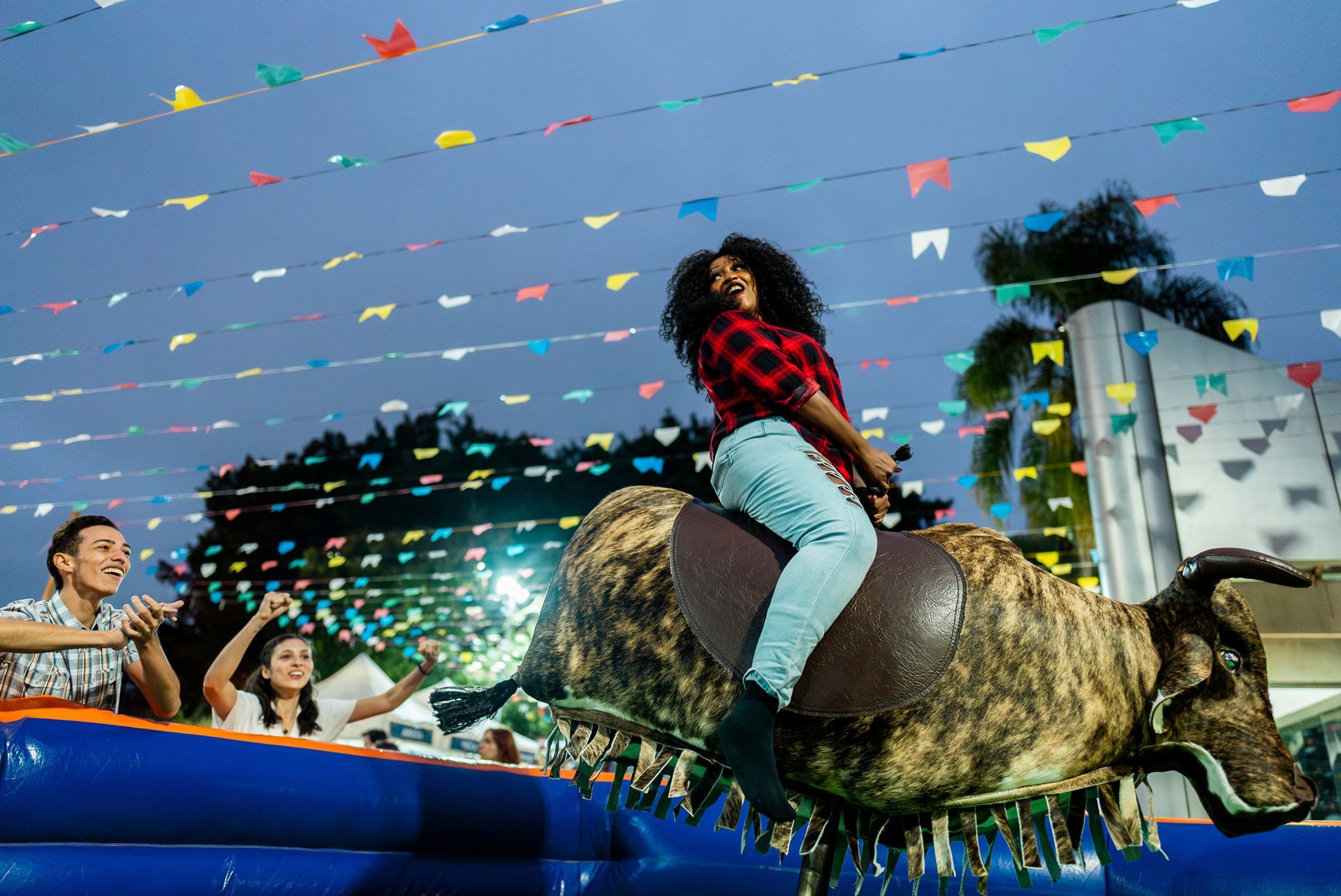A woman is riding a bull at a rodeo.
