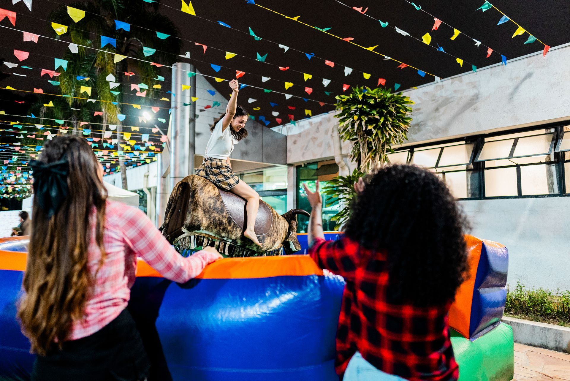 A woman is riding a mechanical bull at a rodeo.
