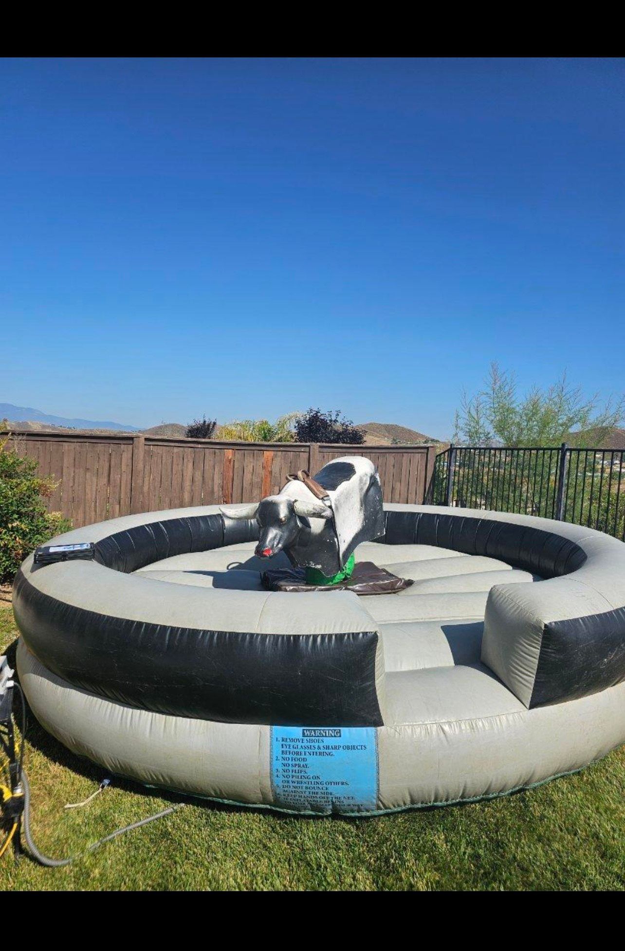 A woman is riding a mechanical bull at a rodeo.
