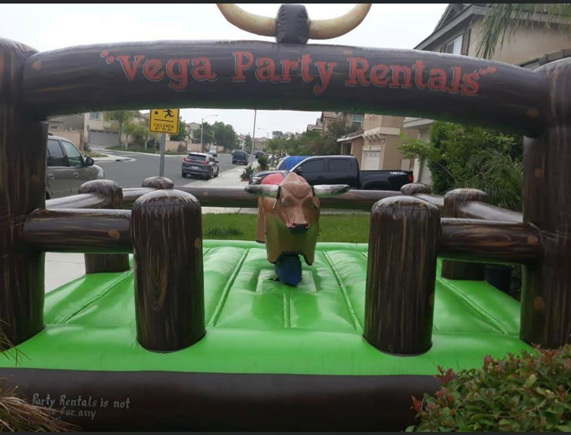 A bouncy house with a bull on it and a sign that says vega party rentals
