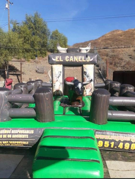 A mechanical bull is sitting on top of a green inflatable maze.