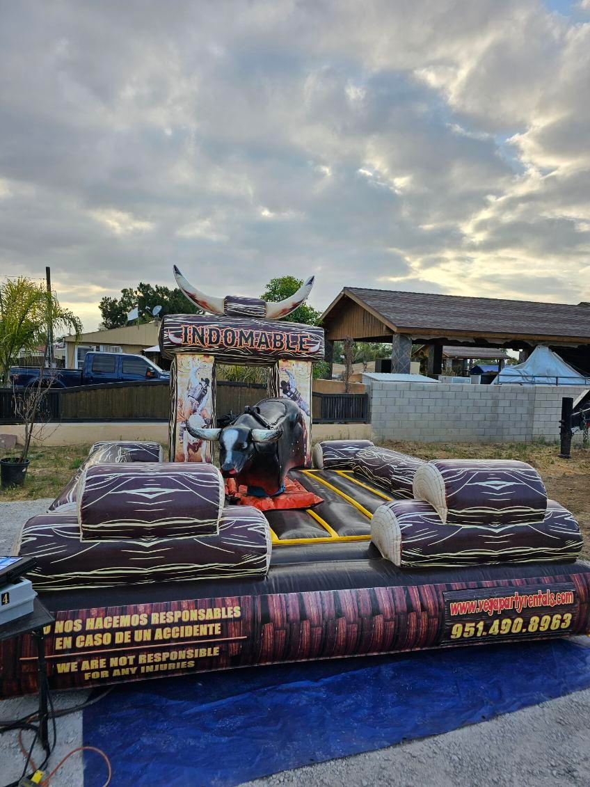 A bull riding ride is sitting on top of a blue tarp.