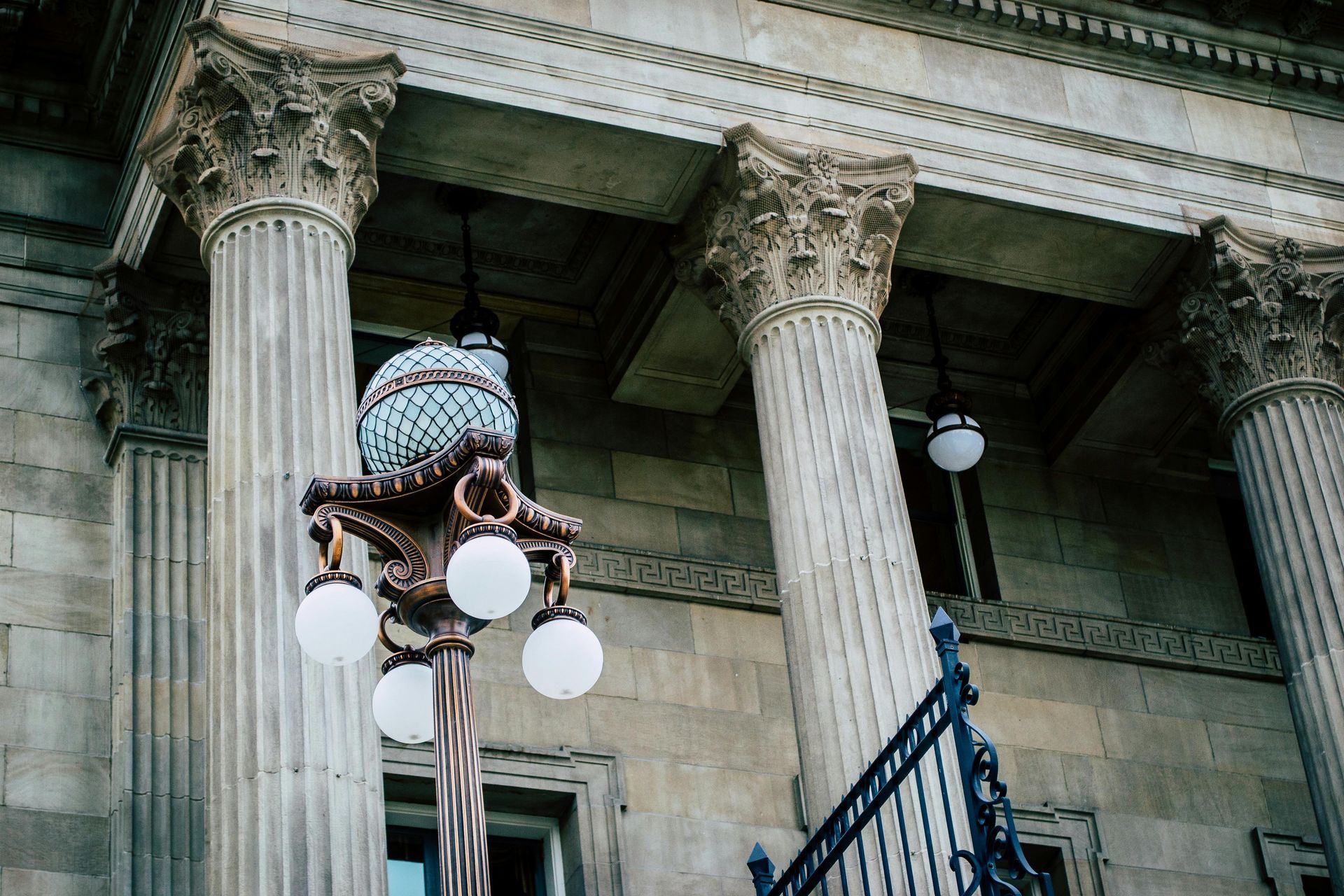 A building with columns and a lamp post in front of it.