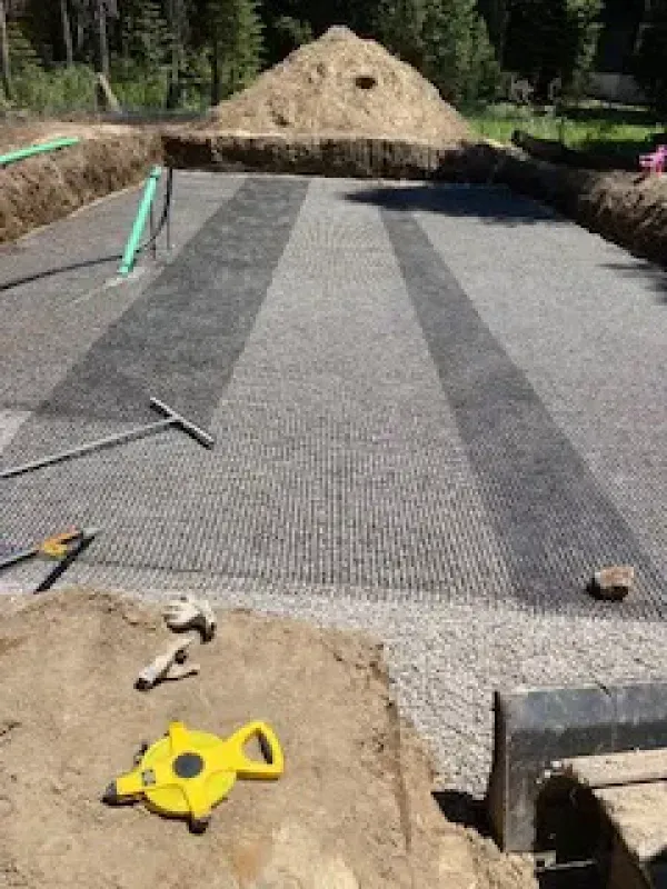 A yellow tape measure is sitting on the ground next to a pile of dirt.