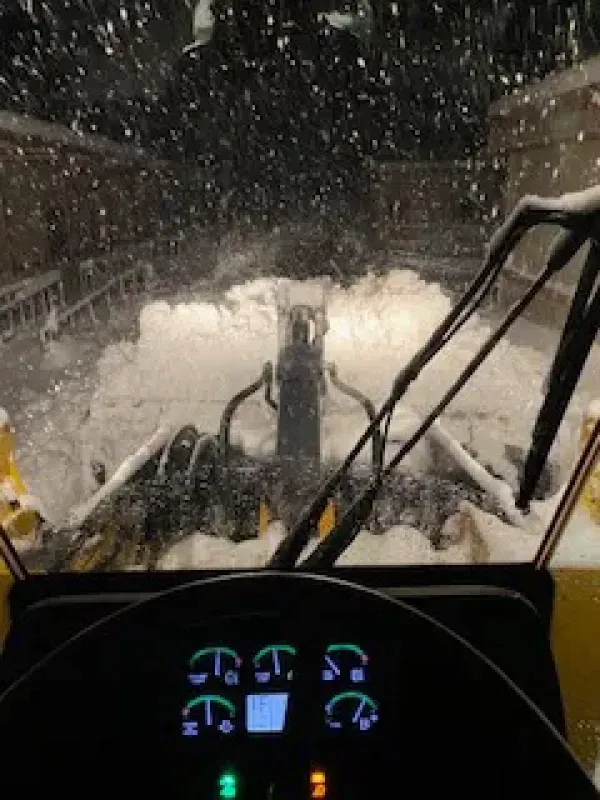A snow plow is clearing snow from a road.