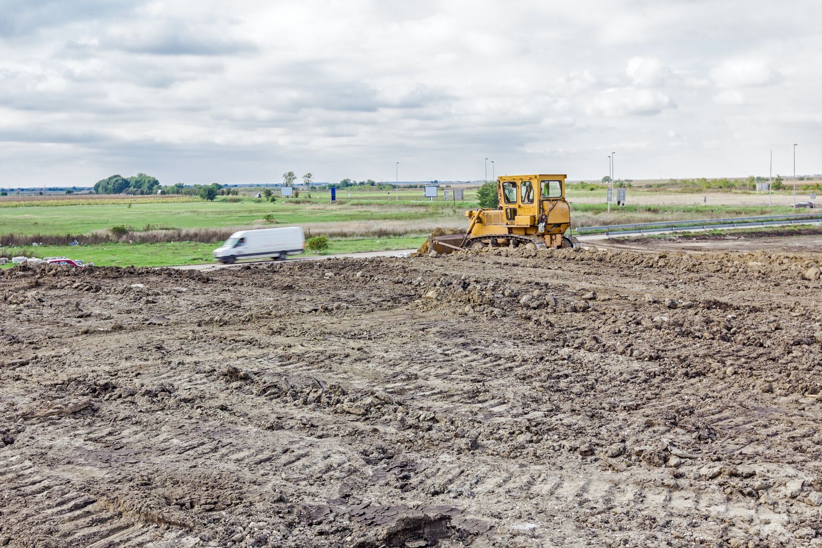 A bulldozer is moving dirt in a field.