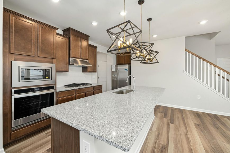 A kitchen with granite counter tops , stainless steel appliances , and wooden cabinets.